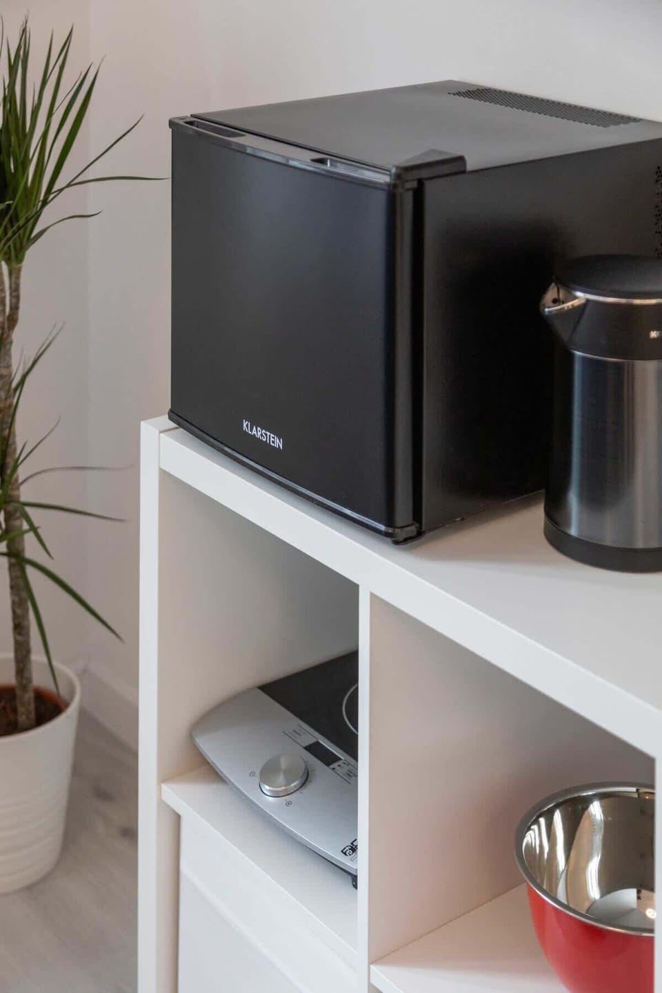 A modern mini-fridge, portable induction stove and a coffee maker - for your convenience!