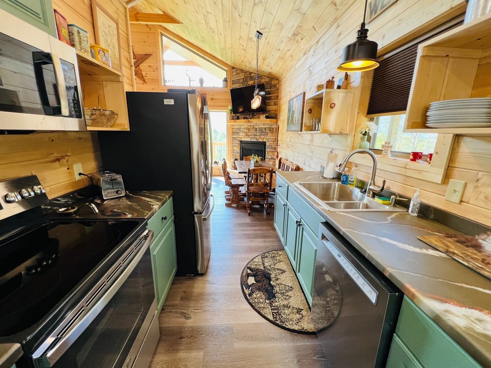 Bright open kitchen with teal cabinetry and full suite of appliances for a comfortable self-catering stay at A Tyme to Chill cabin in Wears Valley, Tennessee.