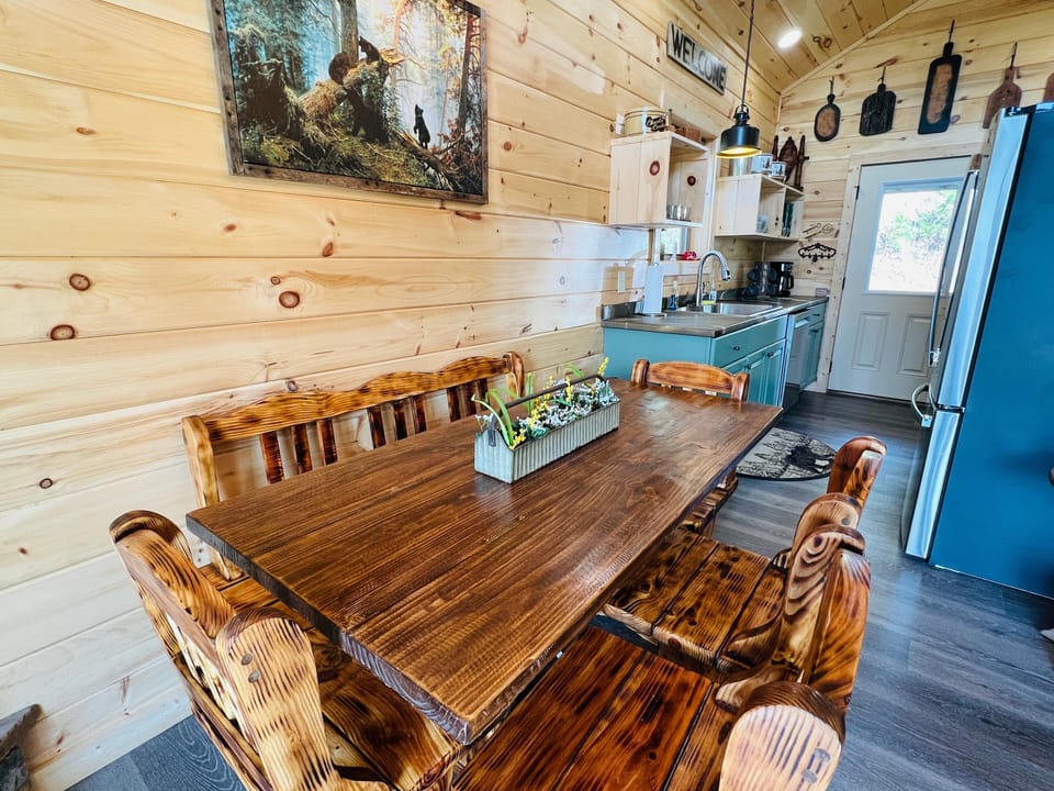 Open-concept kitchen and dining area with teal cabinetry and dining table seating six at A Tyme to Chill cabin in Wears Valley, Tennessee.