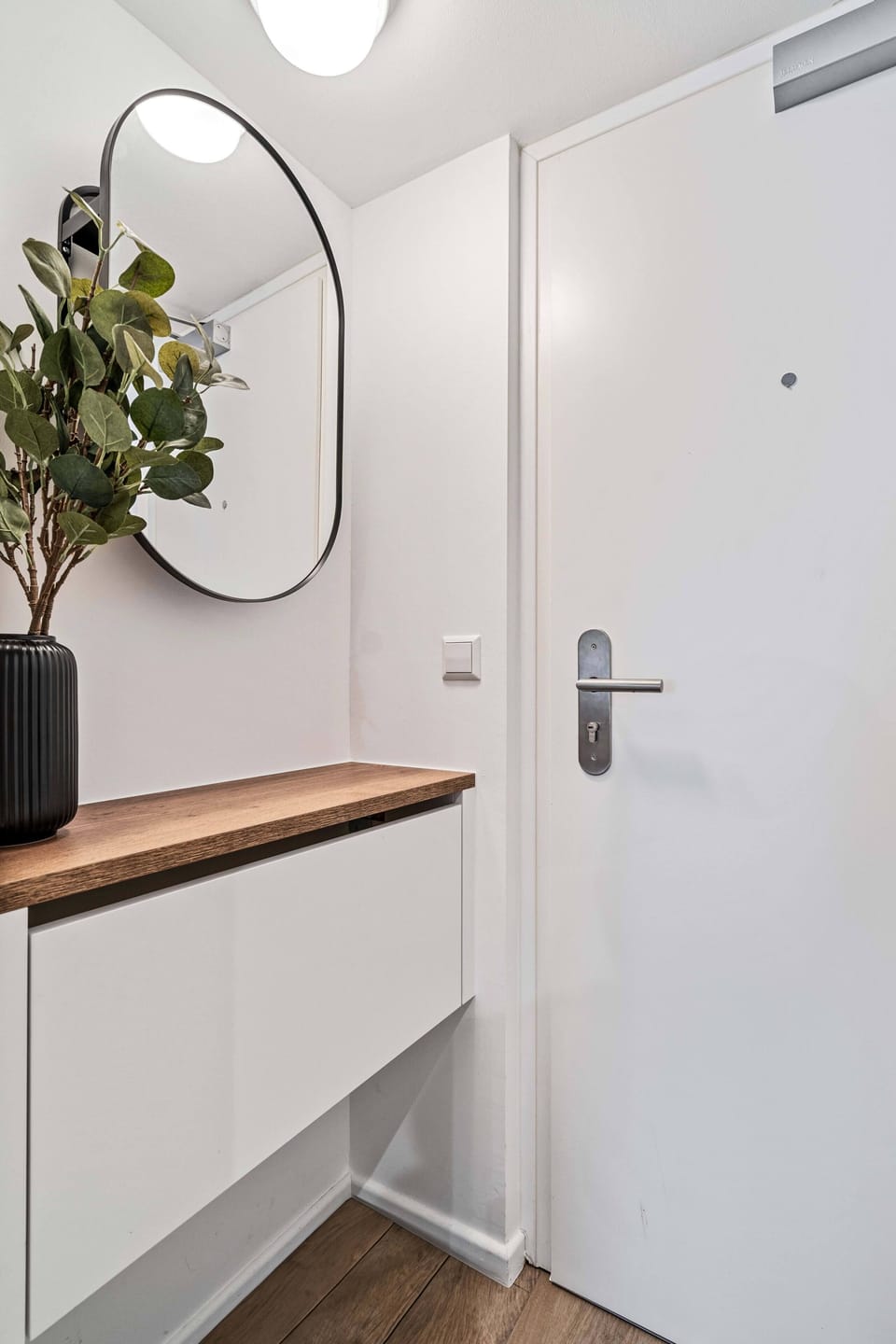 Sleek and modern entryway with a stylish mirror and decorative elements to welcome you home.