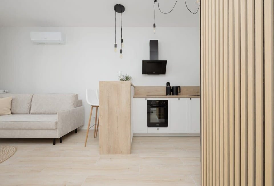 A compact kitchenette with modern cabinets and essential appliances, perfect for preparing everyday meals.