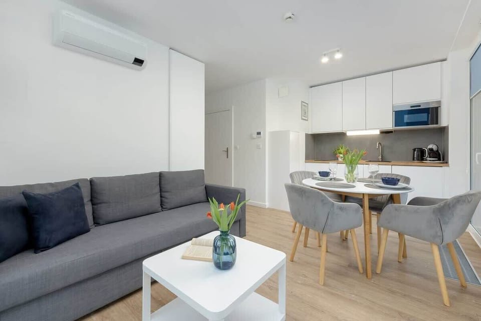 Living room, showing the round dining table and a bright, airy space. The living room is connected to the kitchenette. 