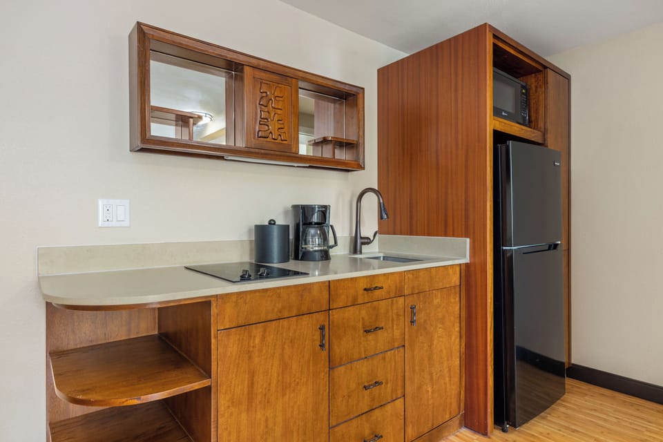 Your fully equipped kitchenette features warm wood cabinetry, a sleek stovetop, and full-size appliances, making it easy to prepare meals and feel right at home during your stay.