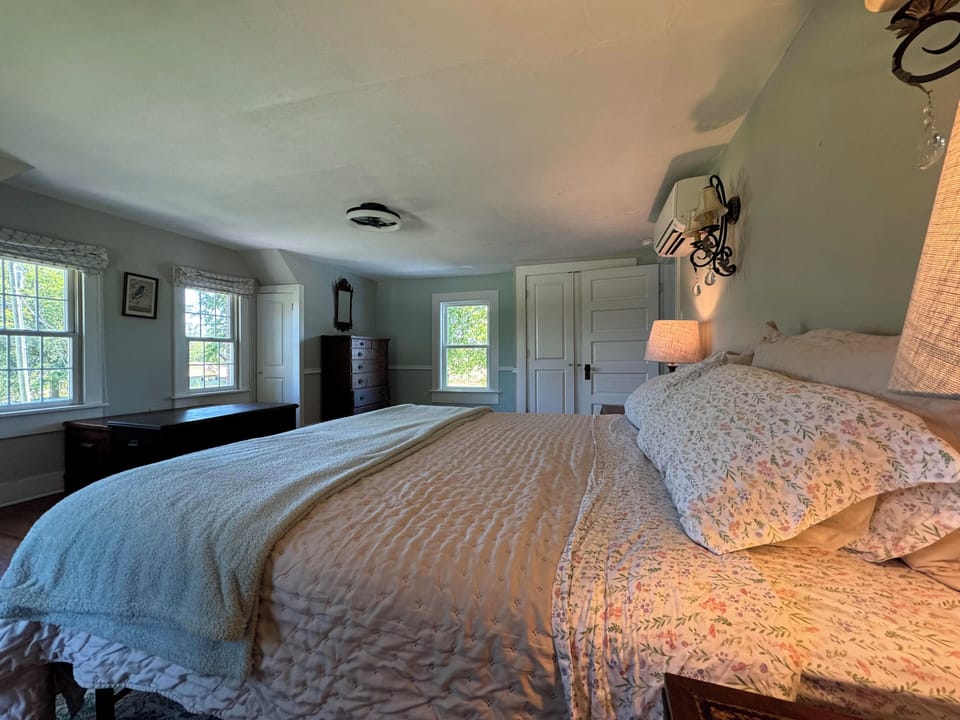 Teal bedroom with views south to the garden and west to the back field and water