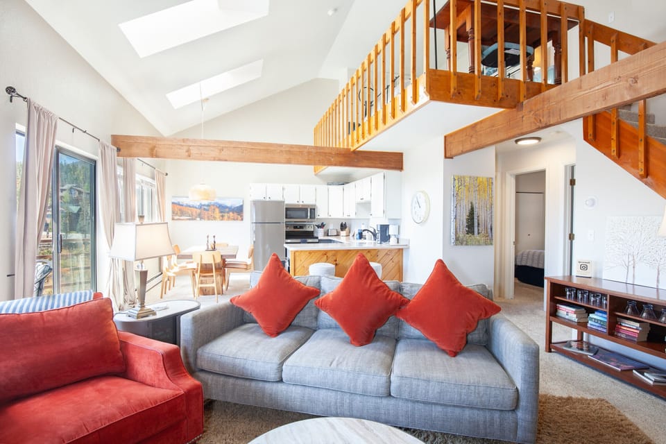 Open floor plan living room has a wood burning fireplace with majestic mountain views