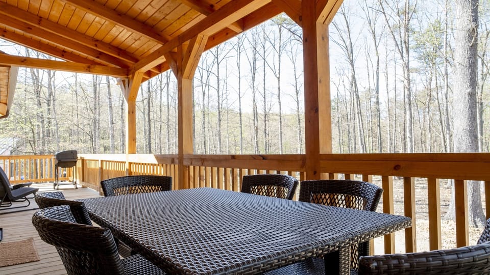 Back deck with dining for 6, a bistro set for two, and a charcoal grill overlooking woods