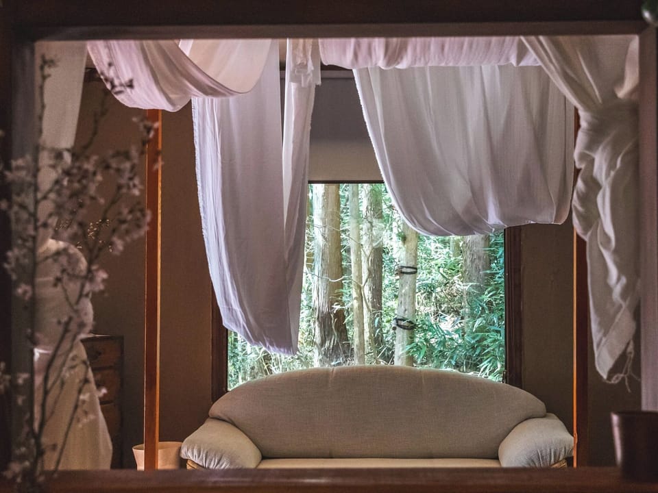 ・[Fall Side] From the bed, you can see the greenery of the trees through the large window.