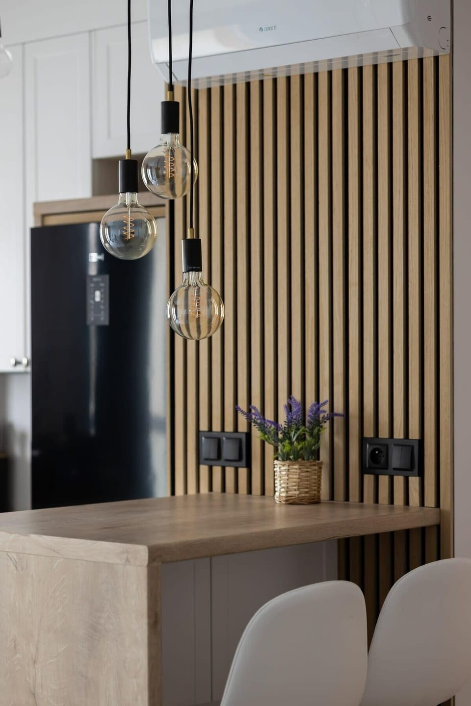 A compact dining area with white chairs and a round table, adjacent to a navy-blue sofa. A cozy space for meals.