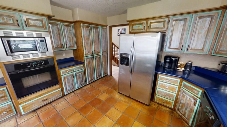 Step into your fully equipped kitchen with stainless steel appliances, warm terracotta tiles, and custom cabinetry—perfect for preparing meals just the way you like them.