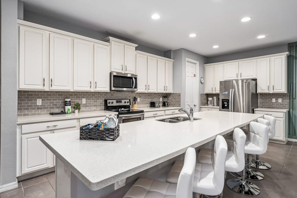 Large kitchen island w/ bar seating, ideal for group meals and prep.