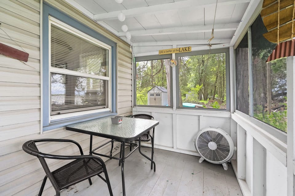 Screened in porch has table with two chairs