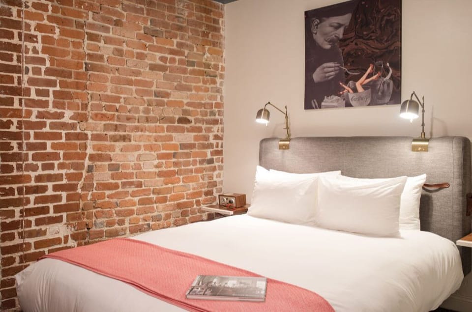 Comfort meets style: bedroom with coral accents against exposed brick