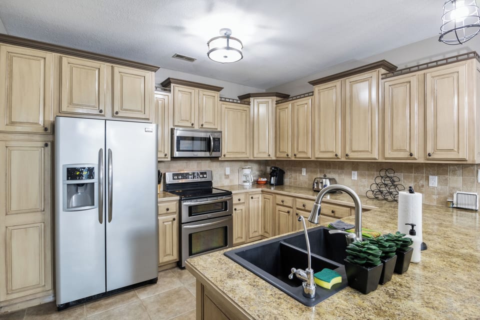 Spacious kitchen equipped with modern stainless steel appliances, plenty of cabinet storage, and a convenient double sink.