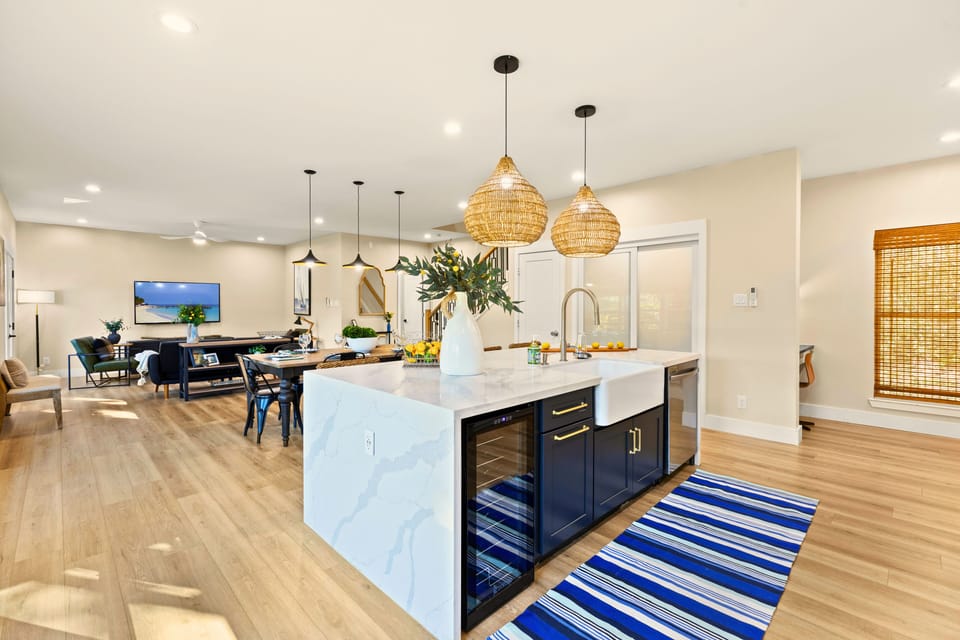 The Black House’s chef’s kitchen is a stunning focal point, featuring a 6-foot waterfall island, wine fridge, custom cabinetry, and a farmhouse sink. Designed with entertaining in mind, it seamlessly flows into the dining and living areas and offers 