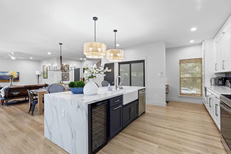 You will love cooking in the beautiful designer Chef's Kitchen with a 6 foot island! It has a wine fridge, built in double trash, farmhouse sink and amazing glass cleaner! The fully equipped chef's kitchen area boasts top-of-the-line appliances and ample counter space, making it a culinary enthusiast's dream for preparing gourmet meals.