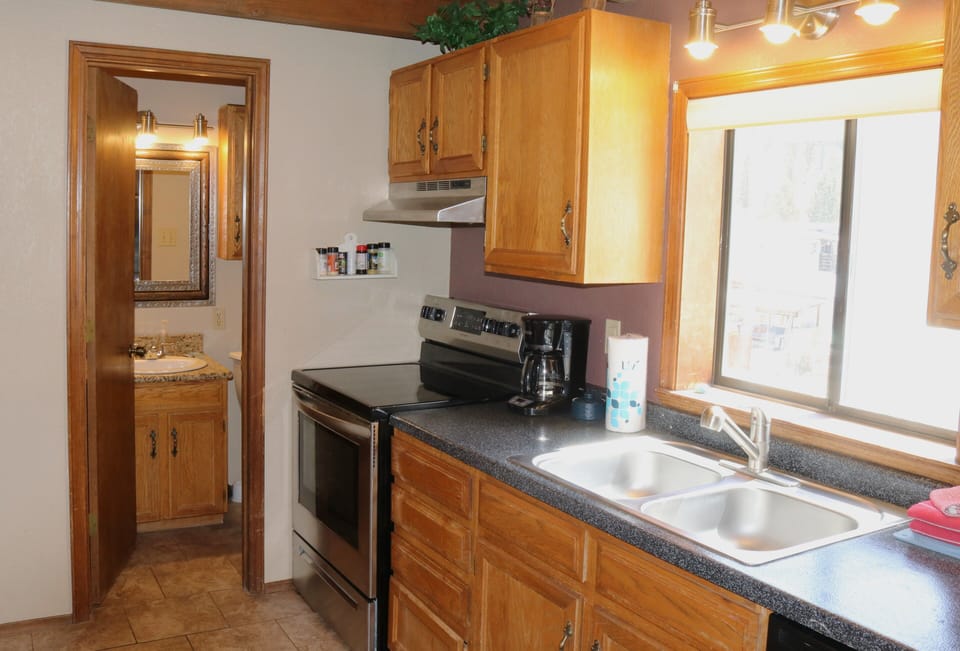 Your fully equipped kitchen features dark granite counters, stainless appliances, and a double sink—perfect for preparing meals during your stay.