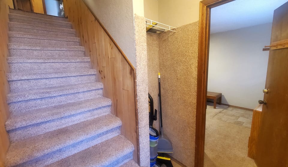 The entry welcomes you with carpeted stairs leading up and a clean, well-lit hallway inviting you to explore your home away from home.