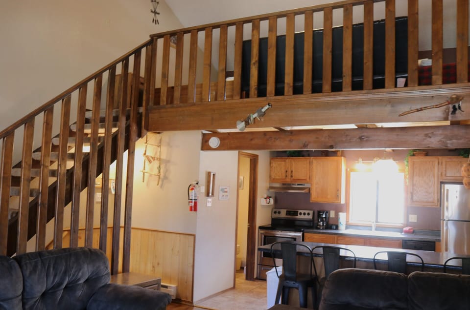 Your loft-style retreat with open kitchen and cozy loft space creates an airy, modern escape. Natural wood tones and vaulted ceilings offer charm and warmth for your stay.