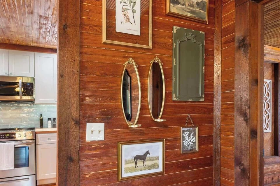 Country Cabin Living: Thoughtful decor and historic textures meet high-end amenities. Take a peek into our fully equipped kitchen, just steps away from the cozy, art-filled living space.