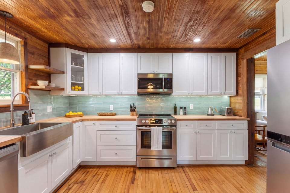 Rustic Elegance & Modern Convenience
Cook with style under gorgeous wood ceilings! Our kitchen features premium finishes, sleek white cabinetry, and a calming tile backsplash. It’s clean, cozy, and fully stocked for your stay.
