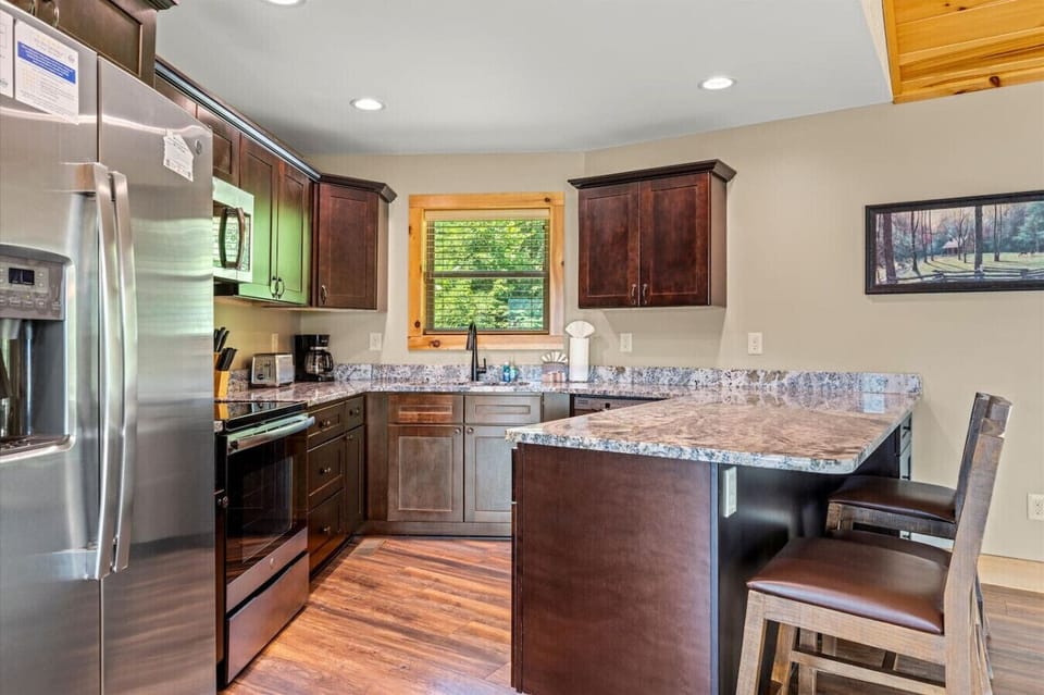 Natural light pours through the window as you prep dinner. Generous counter space, modern appliances, and thoughtful storage make cooking here feel effortless.