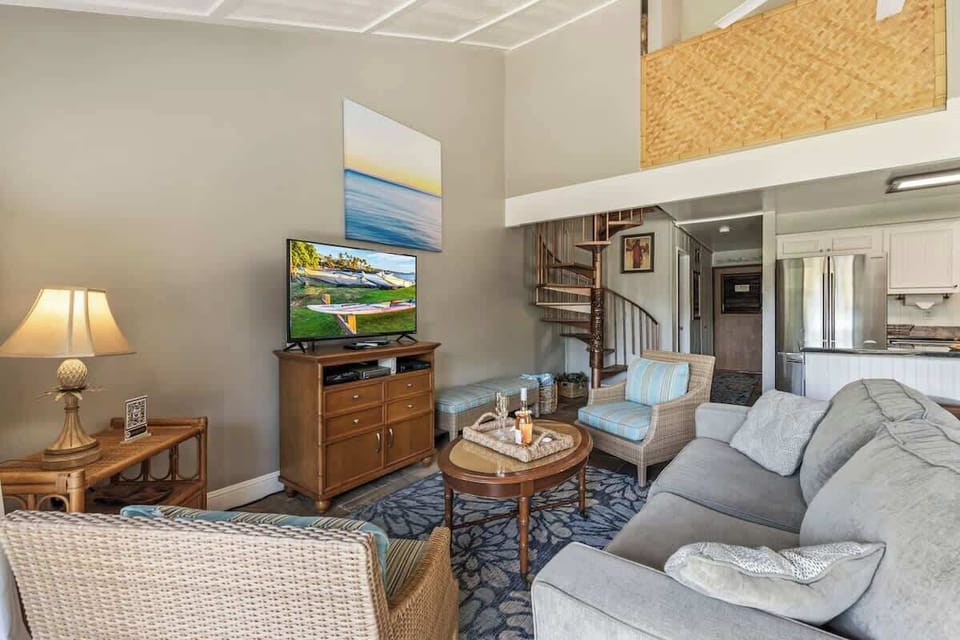 Living area features smart TV with cable, ceiling fan, and plenty of seating 