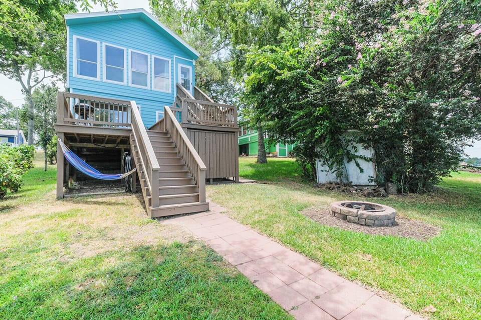 Backyard with hammock and firepit. Lots of lawn chairs available. 