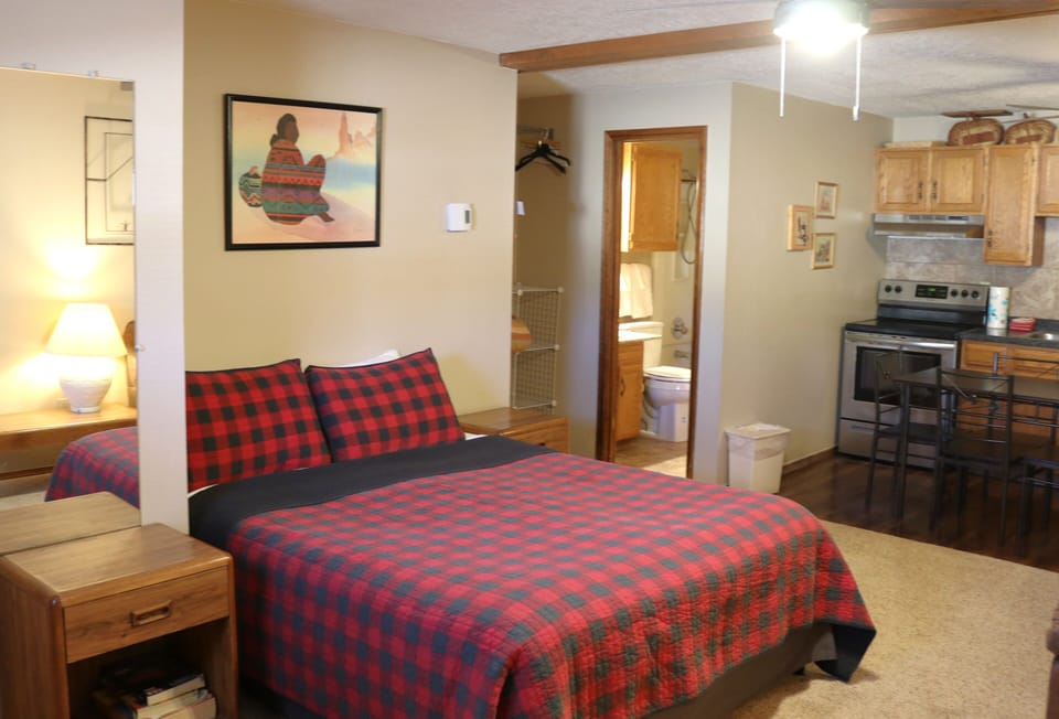 Relax in your cozy bedroom with a plush bed, soft lighting, and everything you need nearby—your private bathroom and fully-equipped kitchen are just steps away.