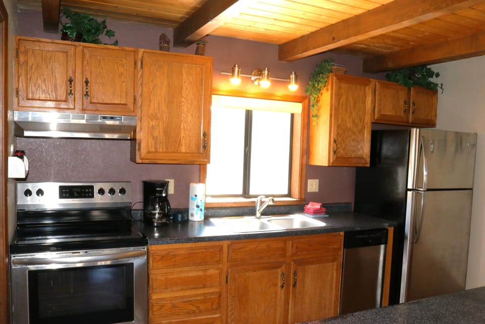 Your fully equipped kitchen features warm wood cabinetry, modern appliances, and all the counter space you need to prepare delicious home-cooked meals during your stay.