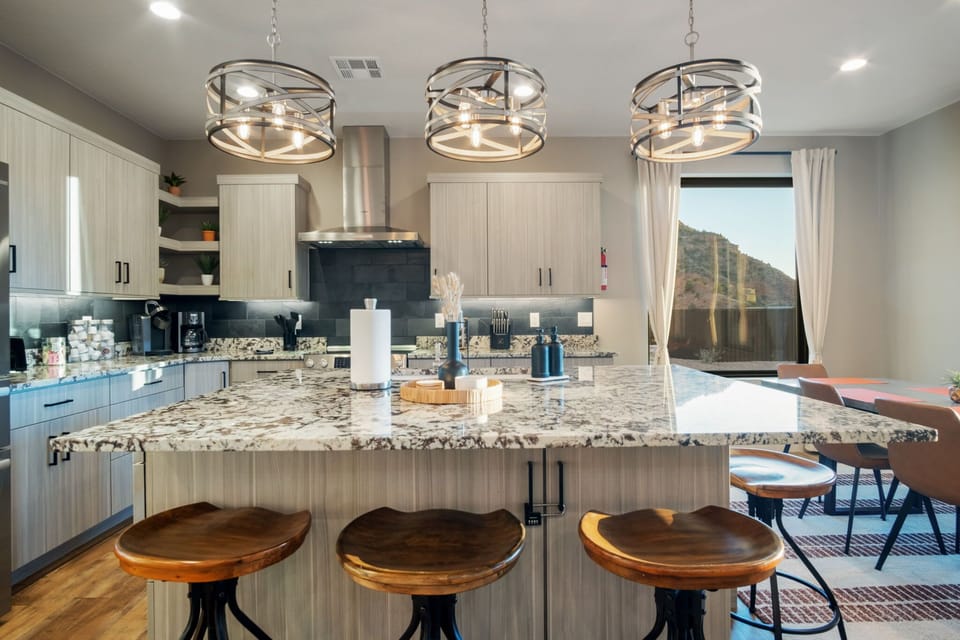 The kitchen features a large dining room table with additional seating for 4 at the bar