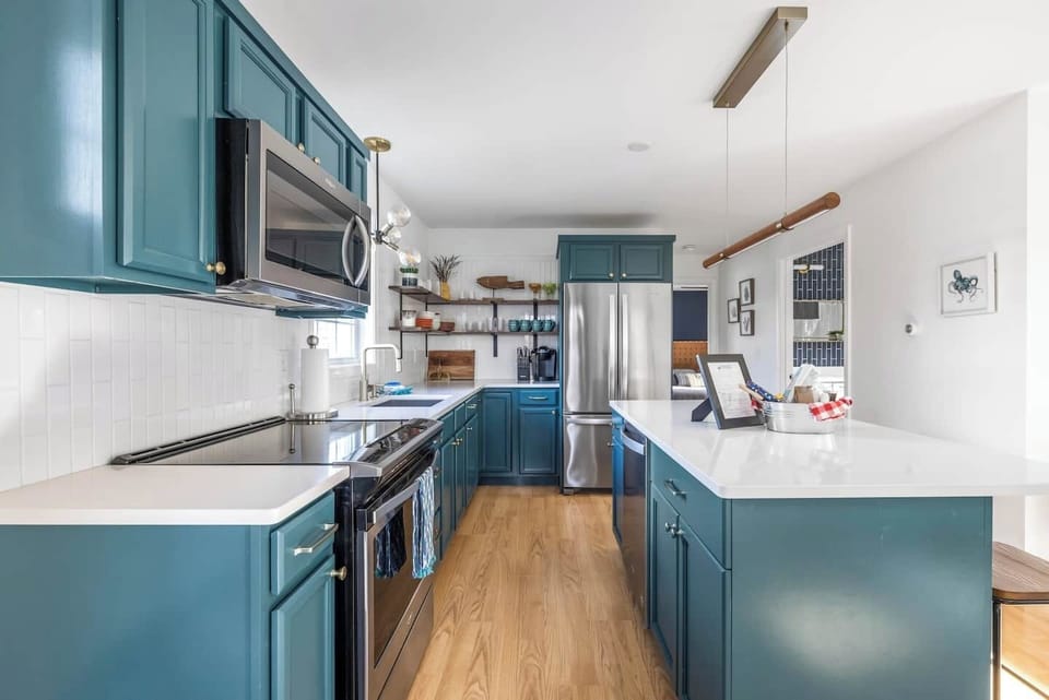 Beautifully designed kitchen featuring bold cabinetry, sleek countertops, and stylish open shelving.