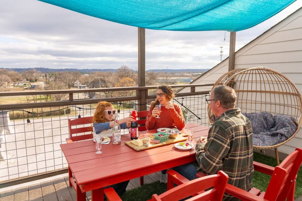 Private rooftop deck with colorful seating for 10, sparkling string lights, and unbeatable mountain views.