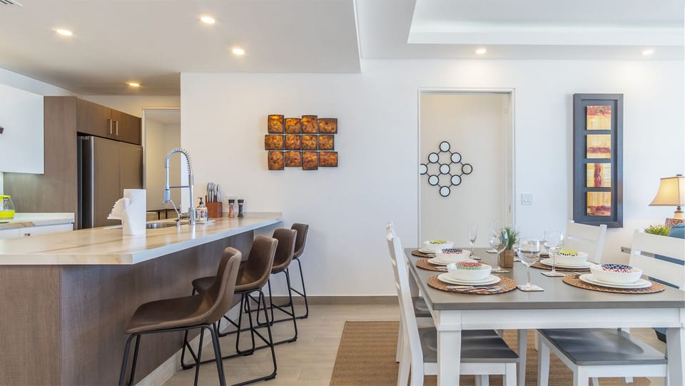 lots of seating between the dining table and the bar stools at the kitchen counter