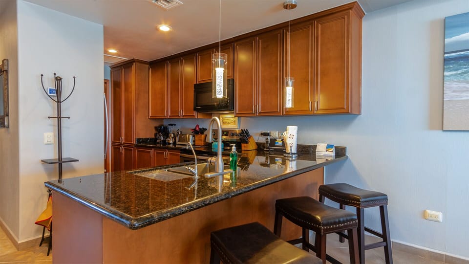 kitchen with many cabinets, full appliances, bar stools