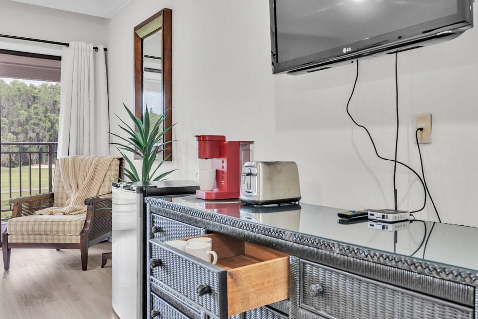 A cozy room with a mini fridge, TV, coffee maker, and a toaster — a perfect blend of comfort and convenience merged into one!