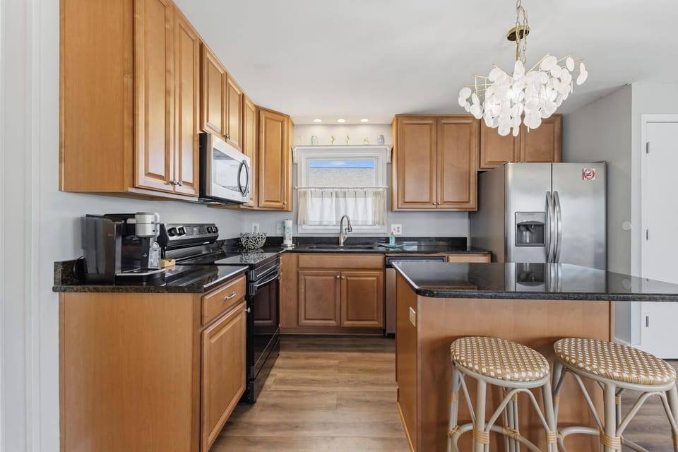 Your fully equipped kitchen features warm wood cabinetry, granite countertops, stainless steel appliances, and a cozy breakfast bar—perfect for preparing home-cooked meals together.