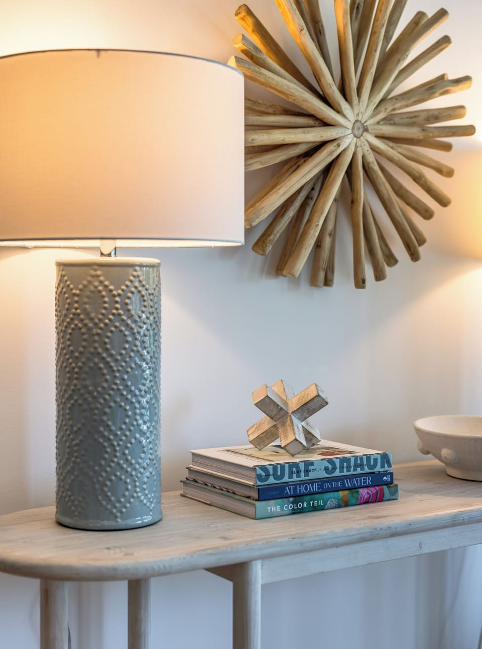 Chic coastal-inspired lamp and décor accents add charm and warmth to this beach retreat.