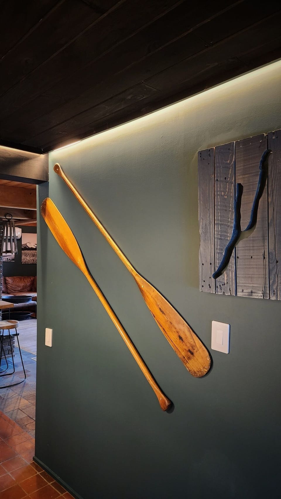 The Hideaway's kitchen features charming wall decor with vintage oars and Keuka Lake artwork, adding a touch of local charm and character. The rustic barnwood accents blend seamlessly with the decor, creating a warm and inviting atmosphere.