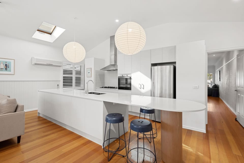 The adjacent kitchen, functional and sleek, is equipped with a full suite of appliances