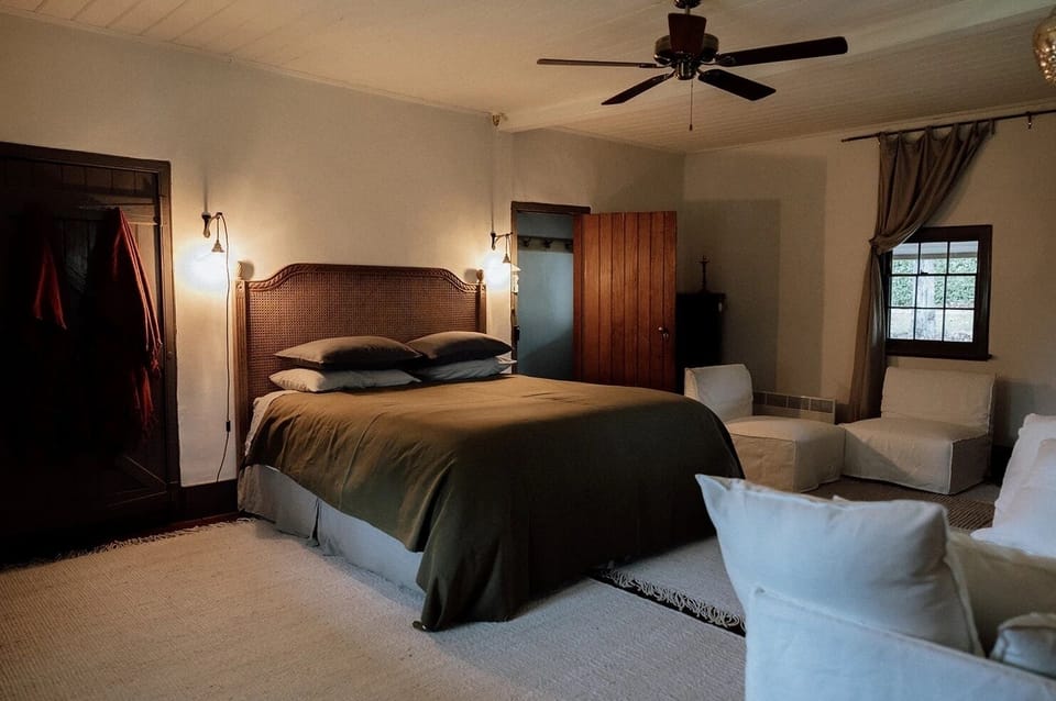 Bedroom 1 - King bed with luxury linen bedding, couch and slow combustion fire