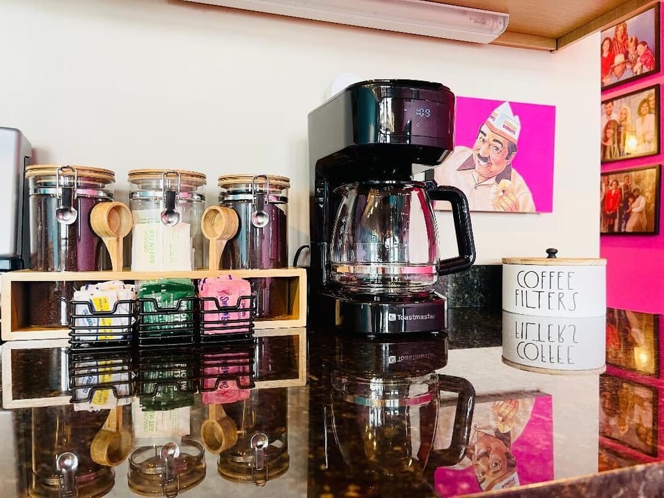 Kick start your day at our fully stocked coffee bar, complete with all your favorite brews and 80s-inspired mugs. This cozy nook blends functionality with nostalgic charm, perfect for coffee lovers and retro enthusiasts alike.