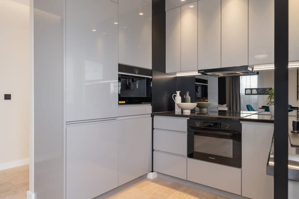 Sleek, modern kitchen with white cabinetry, under-cabinet lighting, and built-in appliances.

