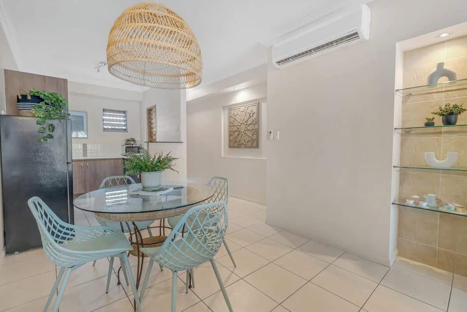 The open plan living space is equipped with split-type cooling and a dining table for four. 