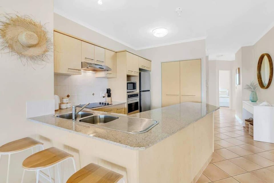 A fully-equipped kitchen has breakfast bar seating and premium appliances including an oven, a Nespresso machine, and a dishwasher