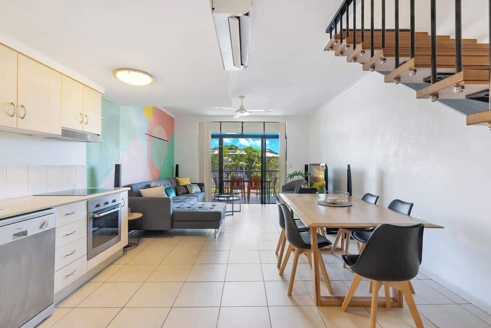 The dining area is open and airy, seamlessly connecting to the living area and kitchen.