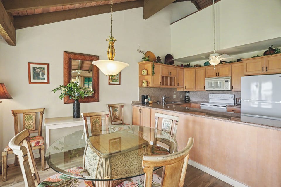 Your spacious open-plan living space features vaulted ceilings with warm wood accents, a fully equipped kitchen, and a welcoming dining area perfect for gathering over shared meals.