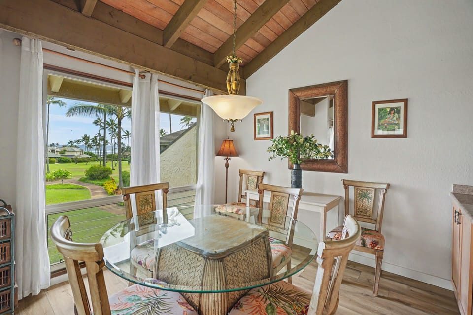 Gather around the island-style dining table beneath exposed beam ceilings, where palm trees sway through your window and tropical breezes set the scene for memorable meals together.