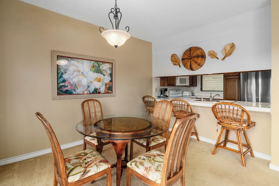 Gather around the elegant dining table where tropical-inspired decor and an open kitchen create the perfect spot for your morning coffee or evening meals together.
