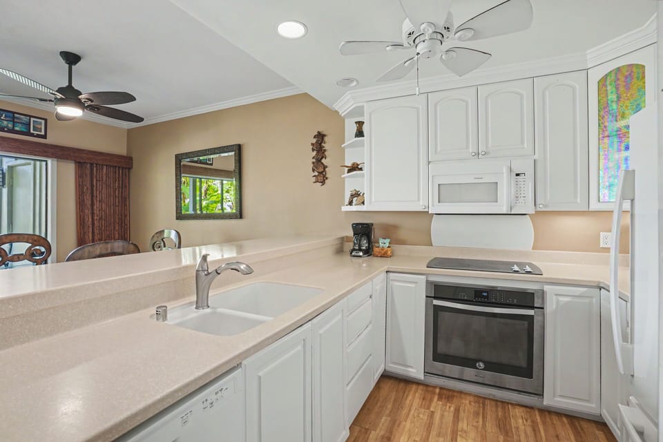 Step into your bright, fully equipped kitchen with modern appliances, generous counter space, and coastal charm—perfect for preparing family meals together.