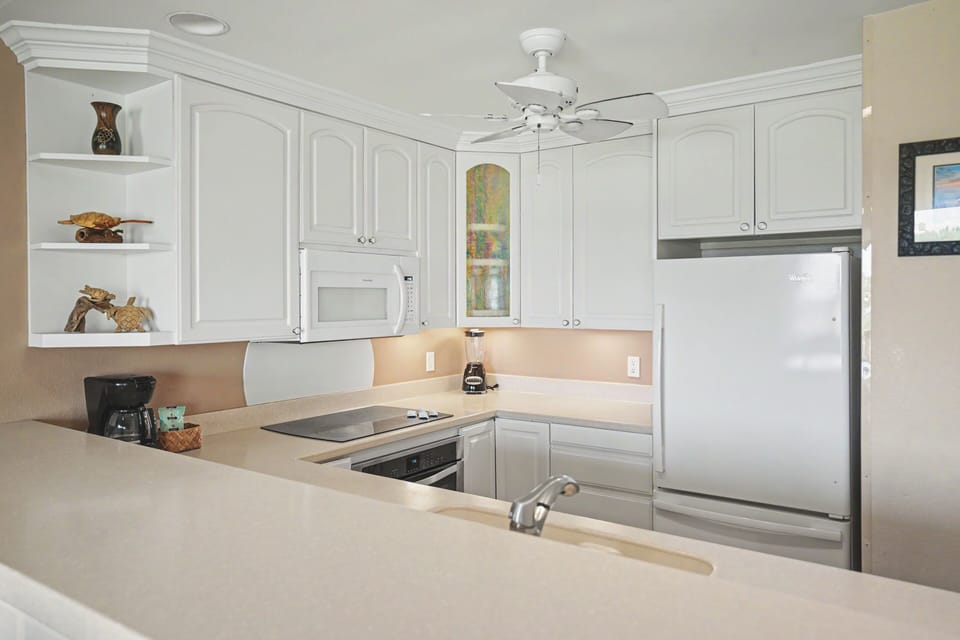 Your fully equipped kitchen features white cabinetry, modern appliances, and plenty of counter space for preparing meals during your stay.